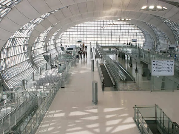 Open airport concourse with glass roof and escalators