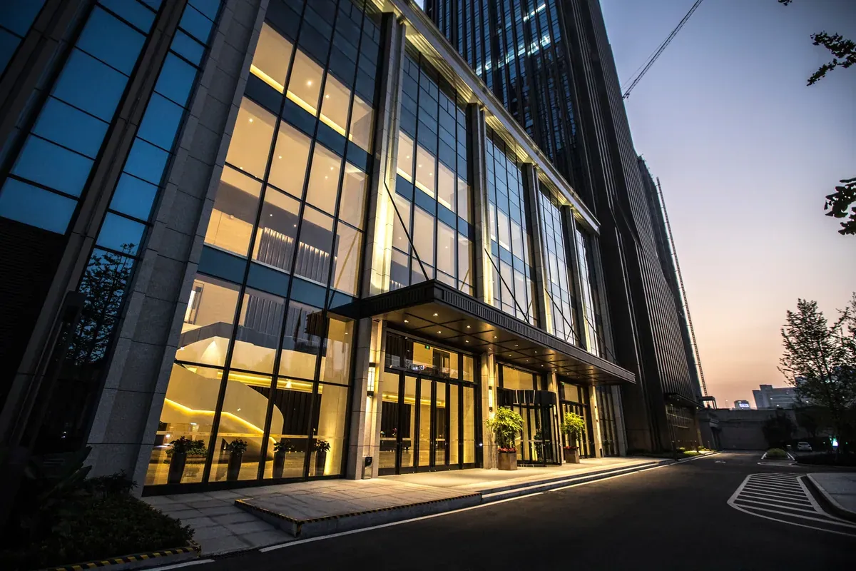 Glass-fronted commercial high-rise lobby at dusk, a smoke curtain application