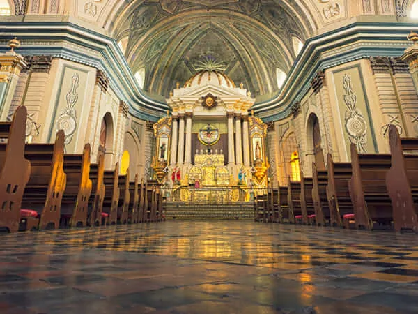 Ornate historic building interior with vaulted ceilings and wooden pews