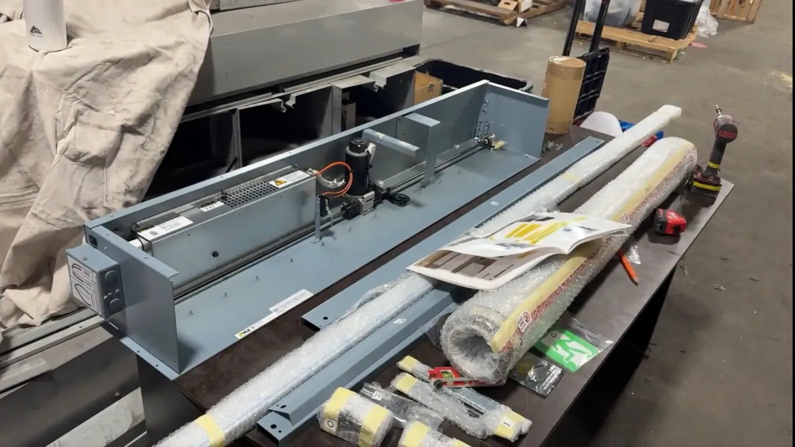 Fire curtain headbox opened on a workbench with motor and drive components exposed
