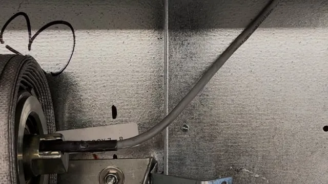Installer mounting a roller bracket during a fire curtain installation